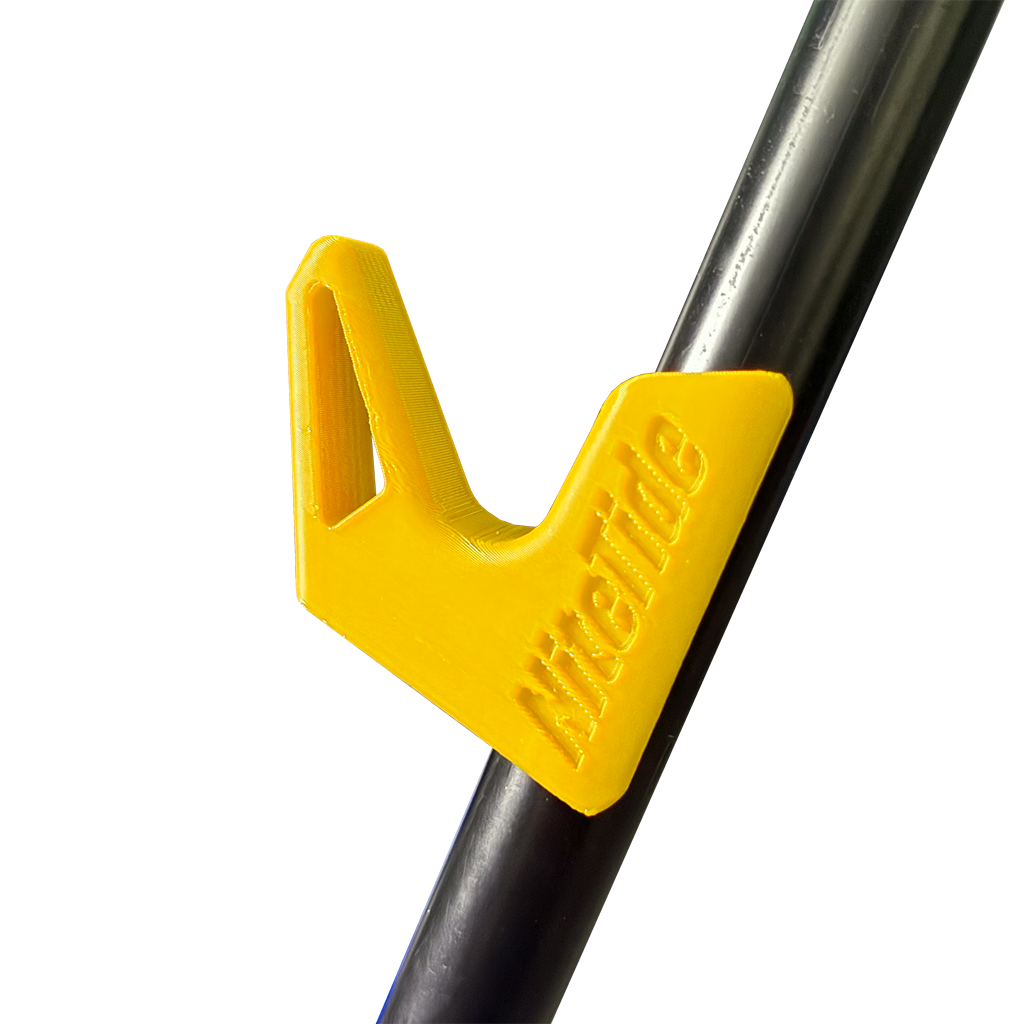 A yellow side rest clip attached to a tripod leg, designed to hold a fishing rod.